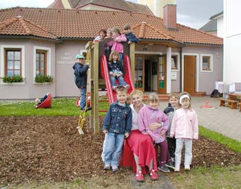 Kinder auf der Schaukel vor Kindergarten Etzen