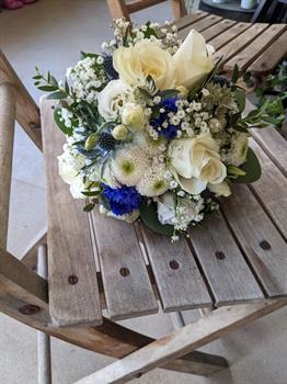 ein Brautstrauß weißer und blauer Blumen